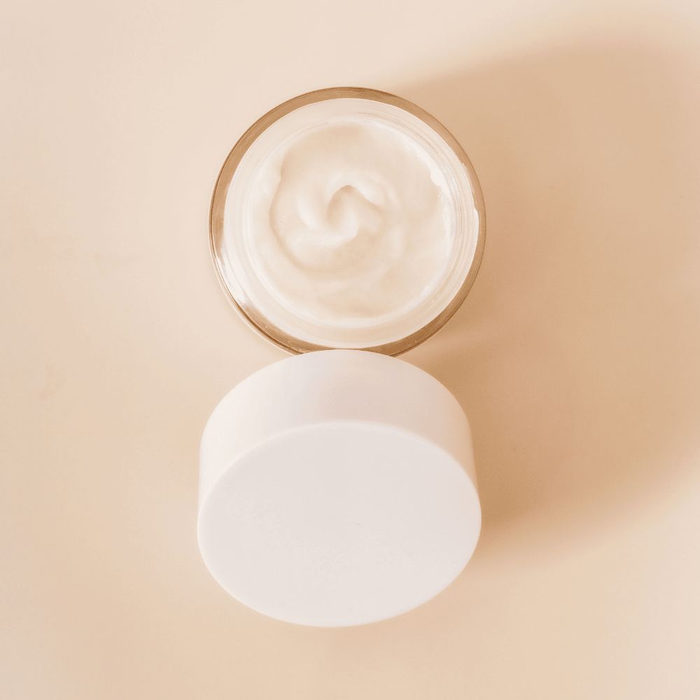 GRAES jar of Night C.A.P. moisturizer with a swatch on a beige background